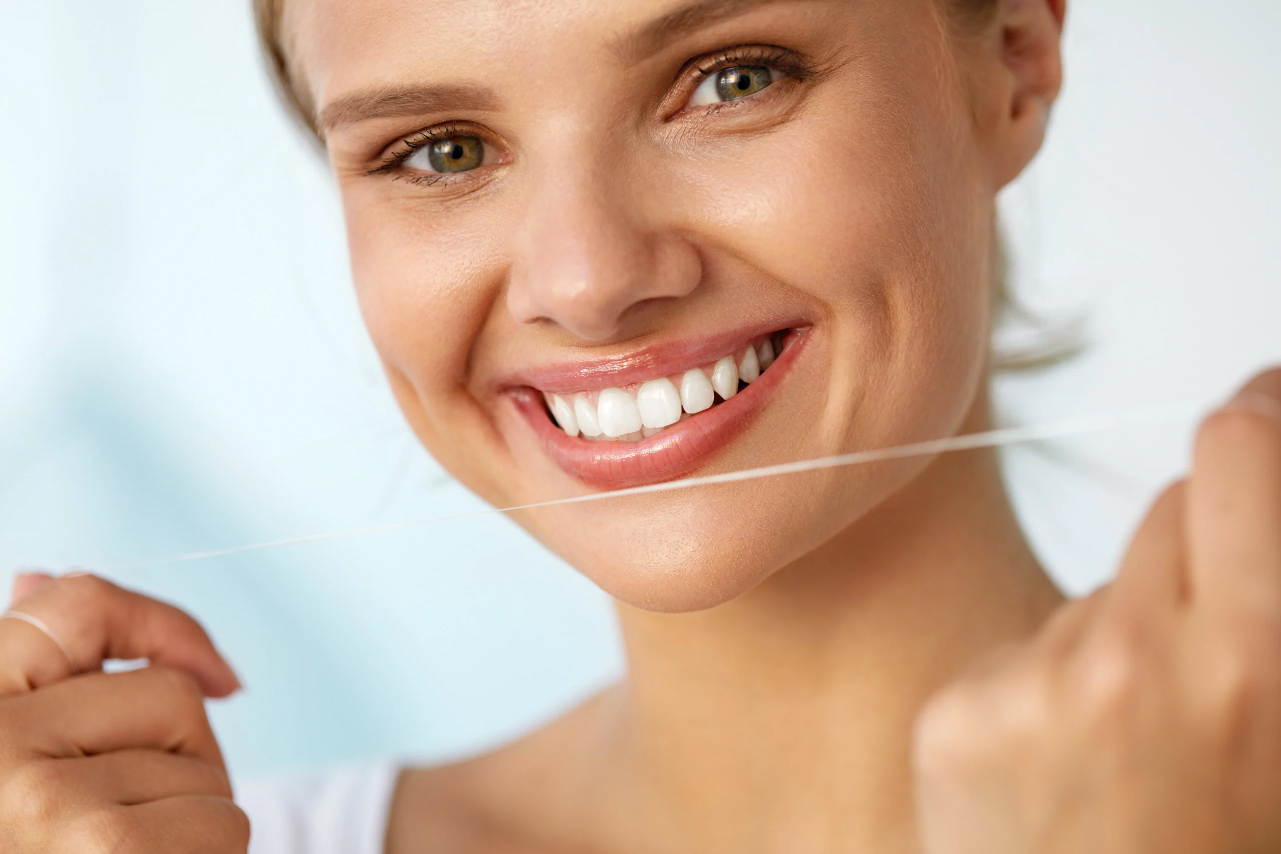 PLDRestorations Woman holding dental floss